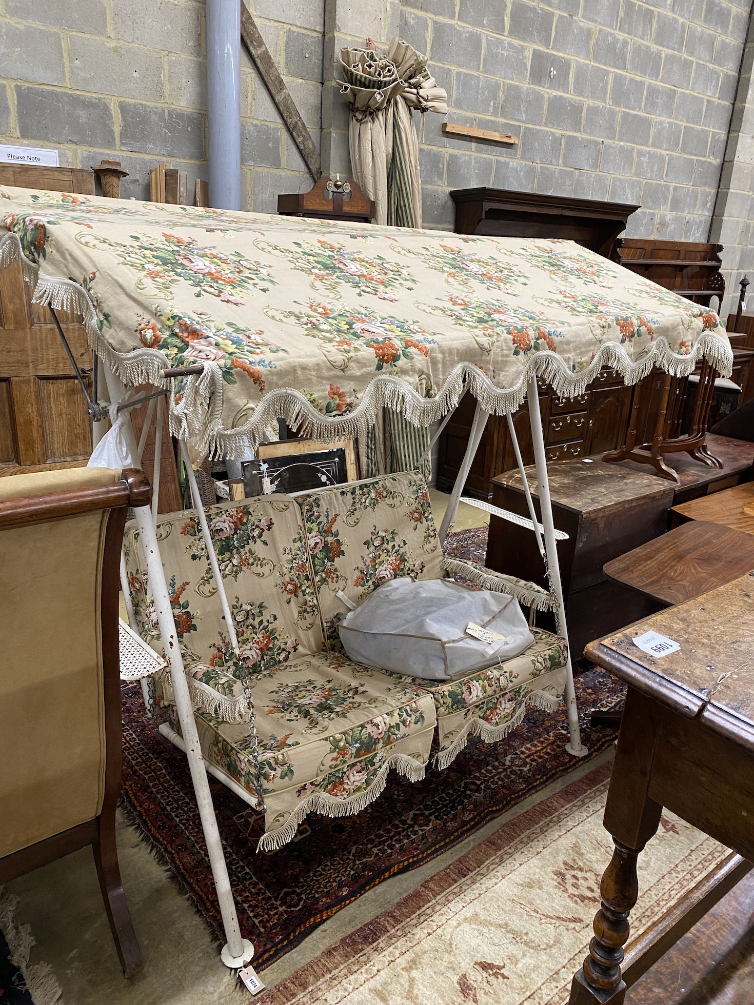 A vintage metal garden swing seat with printed floral covers, width 170cm, depth 104cm, height 180cm